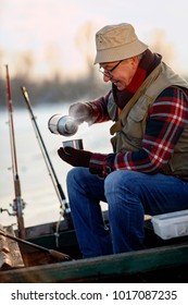 Ice Fishing. Senior Man On Frozen Lake And Drink Hot Tea