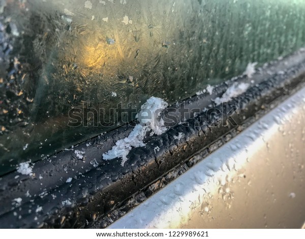 Ice flakes on the side\
window of a car