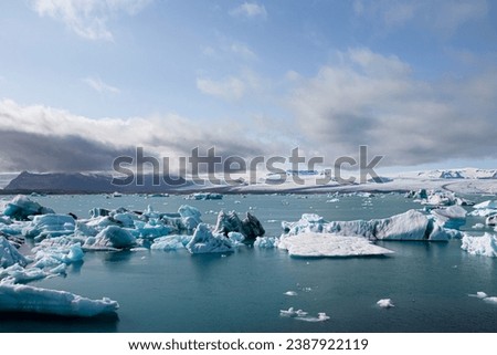 Ice floes in a glacial lake in Iceland with vulcano mountains in the background, the climate crisis in northern Europe, glacial melting, beautiful landsacpe