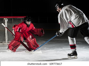 Ice hockey action shot with forward player and goalie.