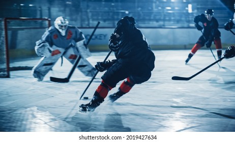 Ice Hockey Arena: Professional Forward Player Breaks Defense, Prepairing to Shot Puck with Stick to Score Goal. Two Competitive Teams Play Intense Game.