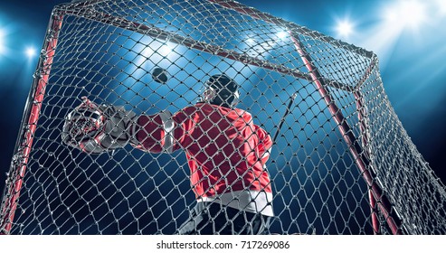 Ice Hockey goalie saves a goal on a dark background with intensional lens flares. He is wearing unbranded sports clothes.