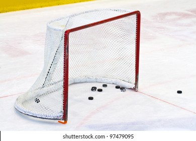Ice Hockey Net With Some Pucks