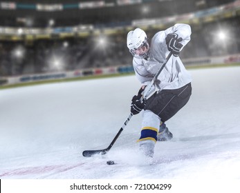 ice hockey player in action kicking with stick in front of big modern hockey arena with flares and lights