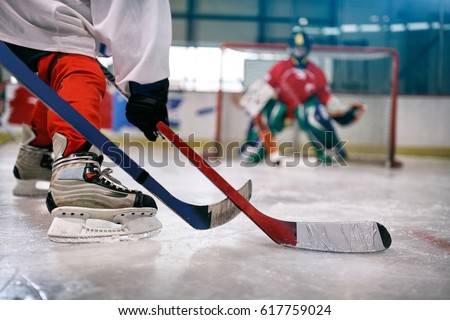 ice hockey player in action kicking with stick on goal