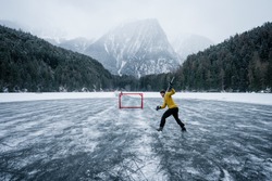Ice Hockey Player Shoots And Scores. Player On A Frozen Pond. Skates On Player Feet During Ice Hockey. Hockey Player Practising On A Frozen Pond Outdoor. 