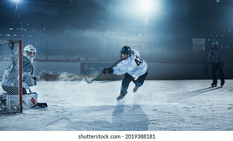 Ice Hockey Rink Arena: Goalie is Ready to Defend Score against Forward Player who Shoots Puck with Stick. Forwarder against Goaltender One on One. Tension Moment in Sport Full of Emotions.