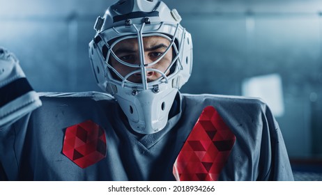 Ice Hockey Rink Arena: Portrait of Brutal Professional Goalkeeper, Wearing Goaltender Mask, Looking at Camera Seriously. Focused Goalie, Determined to Win. Confident Champion Athlete. Close-up Shot - Powered by Shutterstock