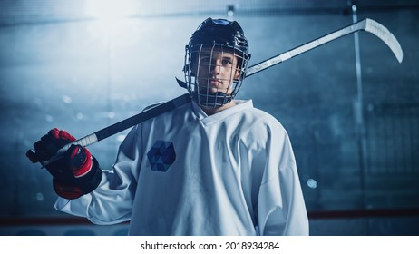 Ice Hockey Rink Arena: Portrait of Confident Professional Player, Wearing Wire Cage Face Mask, Looking at Camera and Smiling. Focused Athlete, Determined to Win and become Champion. - Powered by Shutterstock