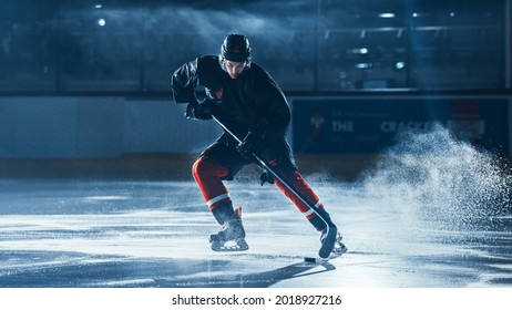 Ice Hockey Rink Arena: Professional Player Training Alone. Skates, Practices Shooting, Hitting, Stricking the Puck with Hockey Sticks. Determined Athlete with Desire to Win, Be Champion.