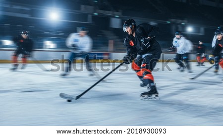 Ice Hockey Rink Arena: Professional Forward Player Breaks Defense, Hitting Puck with Stick to Score a Goal. Blurred Motion Shot.
