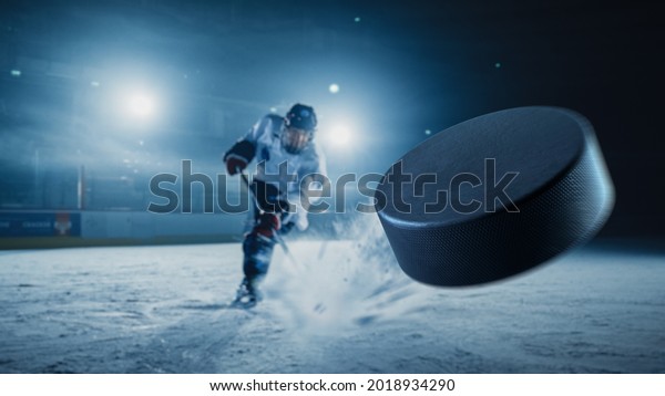Ice Hockey Rink\
Arena: Professional Player Shooting the Puck with Hockey Stick.\
Focus on 3D Flying Puck with Blur Motion Effect. Dramatic Wide\
Shot, Cinematic Lighting.
