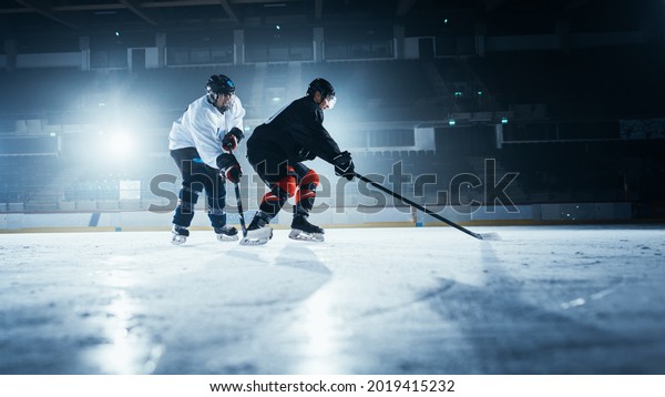 Ice Hockey Rink\
Arena: Two Young Players Training, Learning Stick and Puck\
Handling. Athletes Learn how to Dribble, Attack, Defend, Protect,\
Possesion, Drive the Puck.