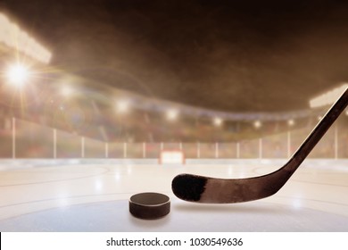 Ice hockey stick and puck in brightly lit outdoor stadium with focus on foreground and shallow depth of field on background. Deliberate lens flare and copy space.