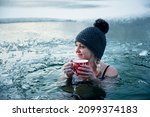 Ice hole swimming, Girl with christmas cup of hot tea in a frozen lake, winter challenge.