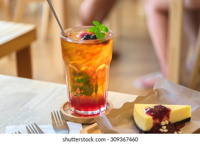 Ice Lemon Tea Mixed With Blueberries And Mulberry In A Glass On The Wood Table In The Coffee Shop.