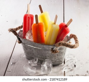 Ice lollies of different flavors in a small bucket with ice cubes. - Powered by Shutterstock