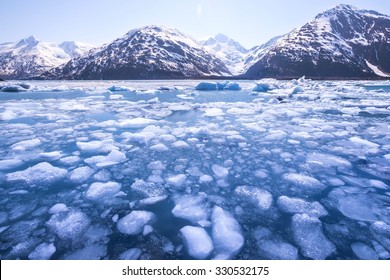 Ice melting in a lake and snow-capped mountains in Alaska. Global warming.