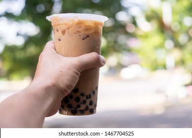 Ice Milk Tea With Bubble Boba In Plastic Glass In Hand Blur Background Are Green Tree And Leaf, Taiwan Ice Milk Tea Fresh Drink 