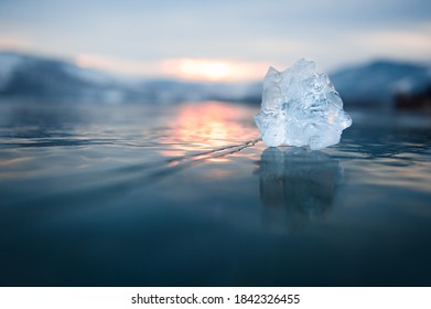 Ice On The Frozen Lake At Sunset. Macro Image, Shallow Depth Of Field. Winter Nature Background