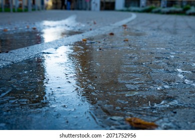 Ice on the street. Frozen puddle. City Centre. The first ice on the footpath. Slippery footpath