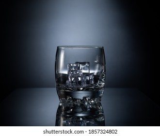 Ice On A Whiskey Glass With A Dark Background.