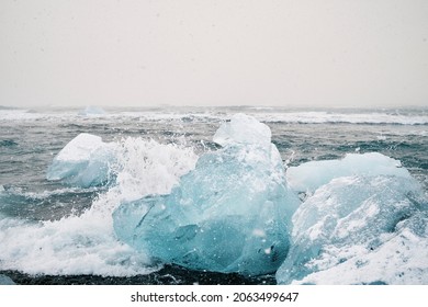 Ice pieces in foamy ocean with splattering water in storm