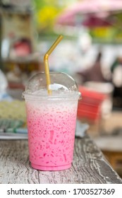 Ice pink milk in a plastic glass