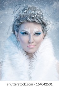 Ice queen - beautiful woman in winter professional makeup with white fur