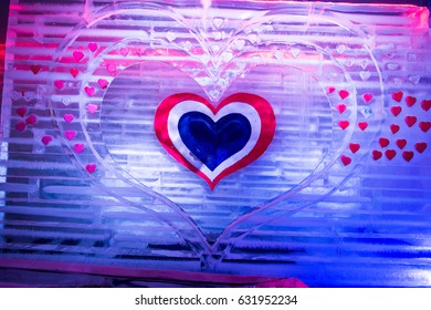 Ice Sculpture Heart. Colored Lights In Background.