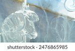 Ice sculpture of toy horse on background of snow slide in ice town. Horse head made of ice close-up. New Year and Christmas. Children