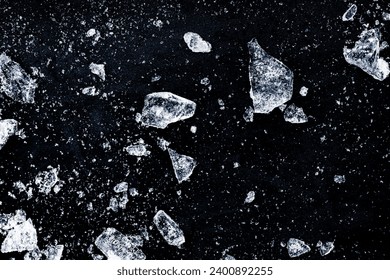 Ice shards crush on a black background. Chill backdrop.