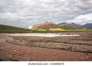 Ice Sheets From The Previous Winter Lay Along The Bank Of A Storm Swollen River Flowing Out Of The Gates Of The Arctic National Park. Looking At The Arctic National Wildlife Refuge And Antigun Valley.