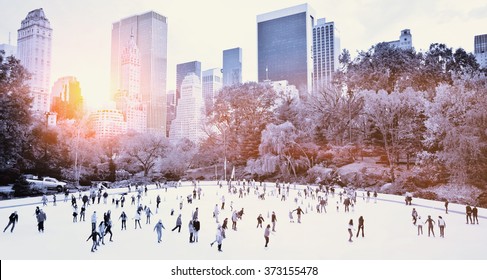 Ice skaters having fun in New York Central Park in fall with sunrise effect