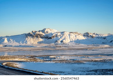 Ice and snow covered Icelandic roads and snow capped mountains in the winter. Nature, travel, winter background or wallpaper - Powered by Shutterstock