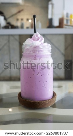 Ice taro latte with whipped cream topping.
