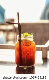 Ice tea with lemon slices and mint on a wooden table