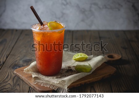 ice tea with slice of lemon in plastic cup on the wooden  background