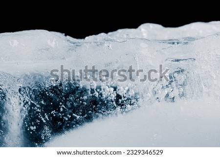 Ice texture background with air bubbles. The textured crunchy piece of ice is on black background.