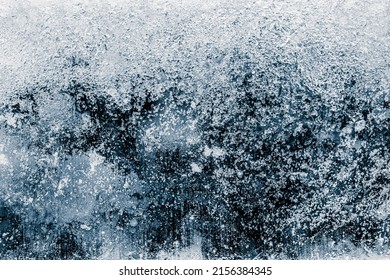 Ice texture background. The textured cold frosty surface of ice block on dark background.