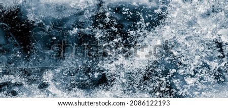 Ice texture background. The textured cold frosty surface of ice block on black background.