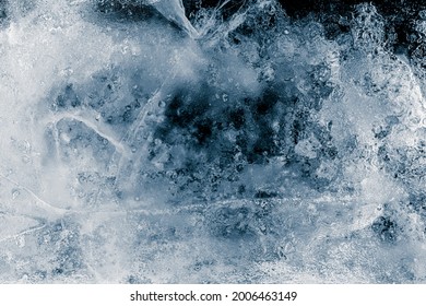 Ice Texture Background. Textured, Dark Blue-toned, The Cold, Cracked, Frosty Surface Of An Ice Block.