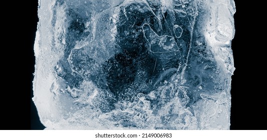 Ice Texture Background. Textured, Dark Blue-toned, The Cold, Cracked, Frosty Surface Of An Ice Block On Black Background.