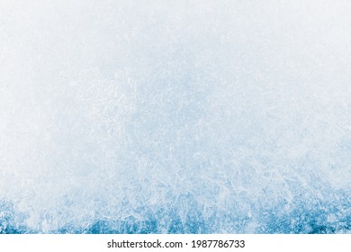Eistexturkristall, blauer Hintergrund. Die strukturierte kalte, frostige Eisoberfläche.