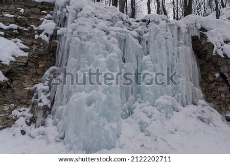 Ice waterfall in winter forest, ice wall like Game of Thrones