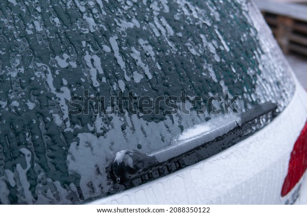 ice from a\
windshield . Car side mirror covered with ice . covered car .\
Windshield Frozen car winter driving . Frosty patterns on a\
completely headlights with icicles and\
snow