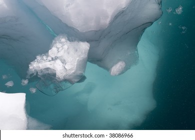 Iceberg Above And Below The Water Surface. Clear Turquoise Colors.