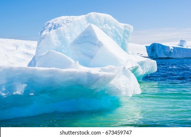 Iceberg In Antarctica, Blue And Green  Ice, Background Sky With Clouds, Sunny Day