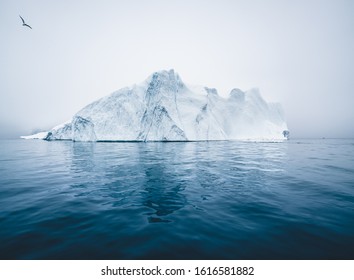 Iceberg and ice from glacier in arctic nature landscape in Ilulissat, Greenland. Aerial drone photo of icebergs in Ilulissat icefjord. Affected by climate change and global warming.