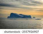 Iceberg in Water at Sunrise